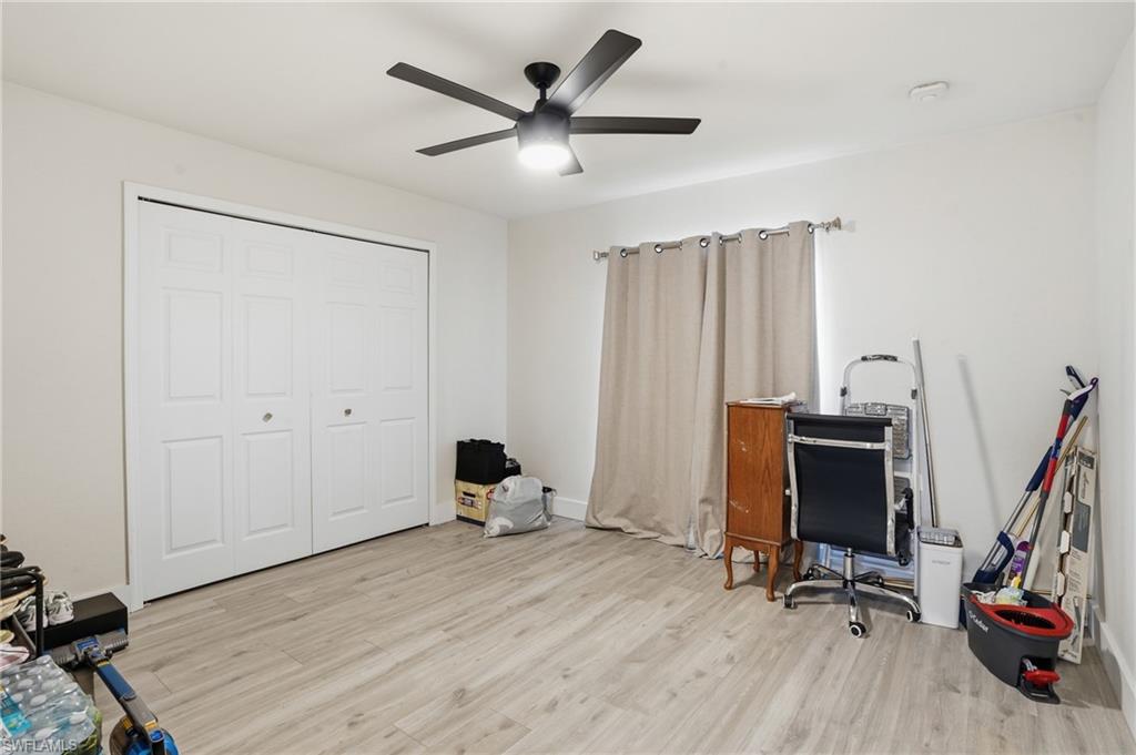 Office space with light wood-style flooring and a ceiling fan