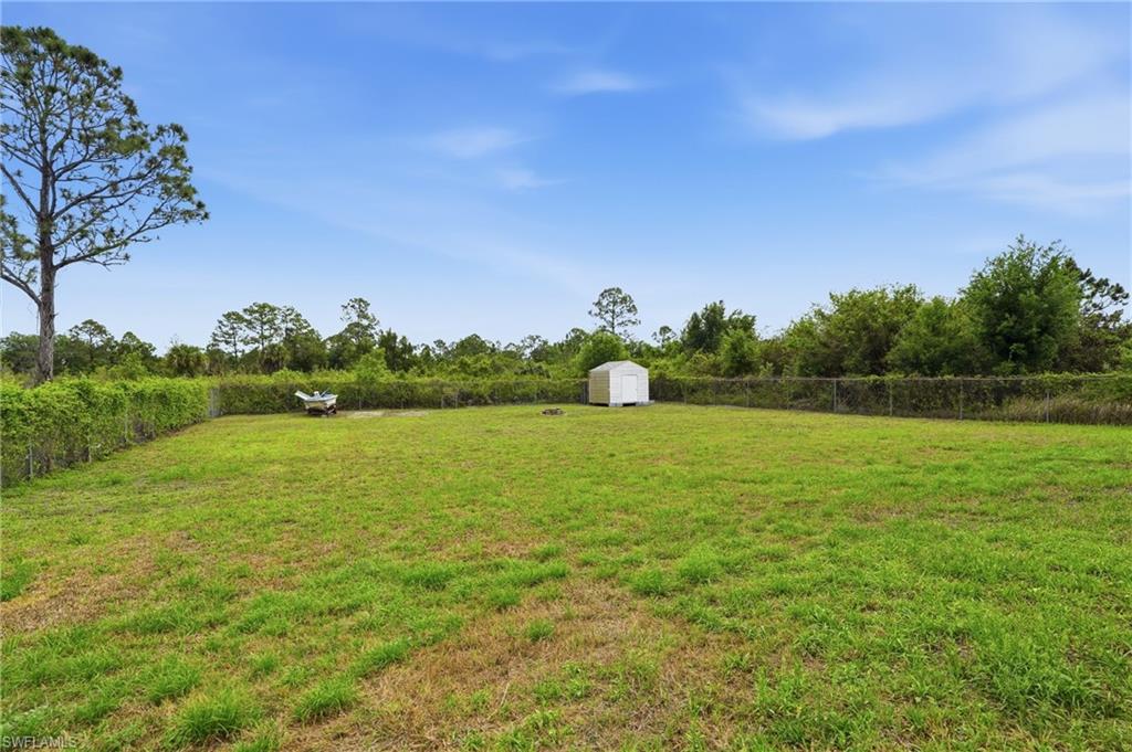 Fenced yard featuring a shed