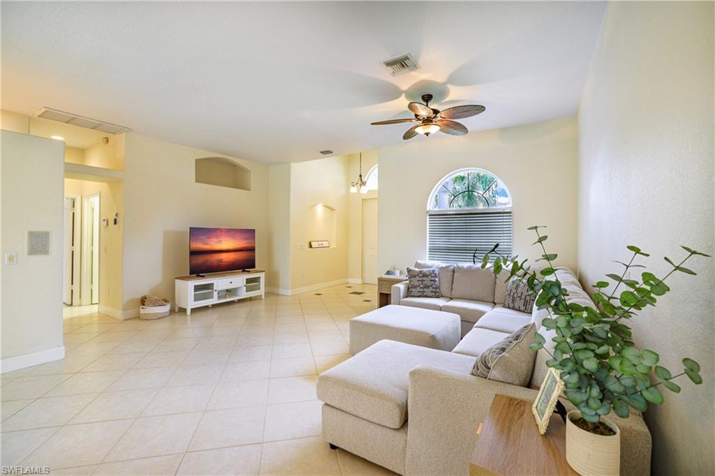 Living room with a ceiling fan and light tile patterned floors