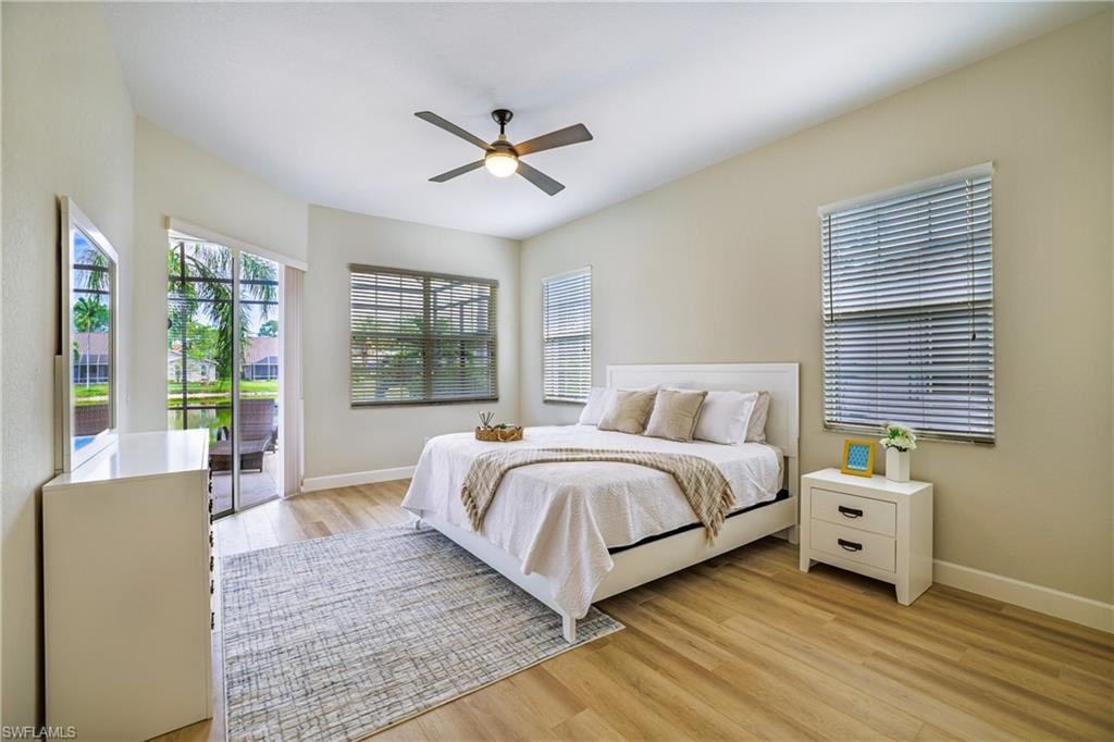 Bedroom with access to exterior, light wood-type flooring, and ceiling fan