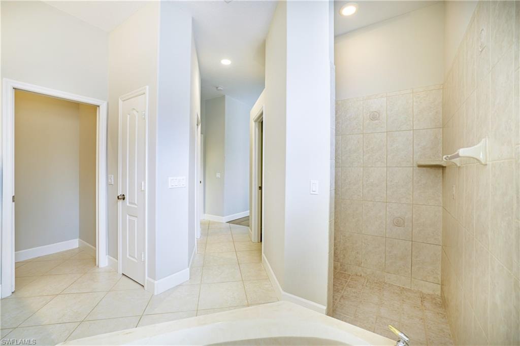 Bathroom featuring walk in shower, light tile patterned flooring, and a bath