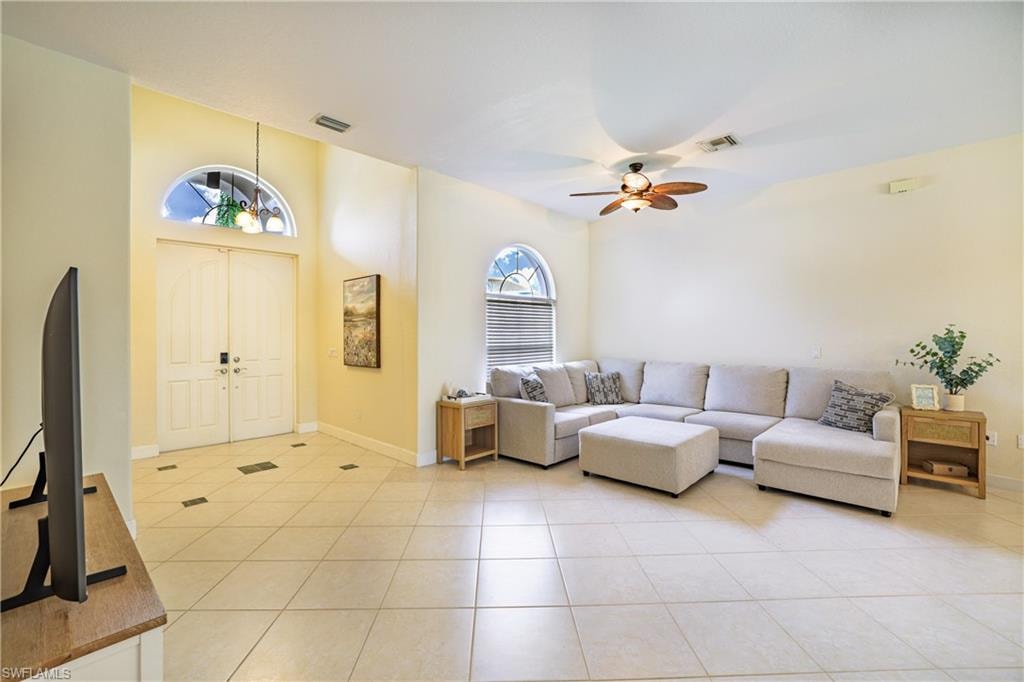 Living room with ceiling fan and light tile patterned floors