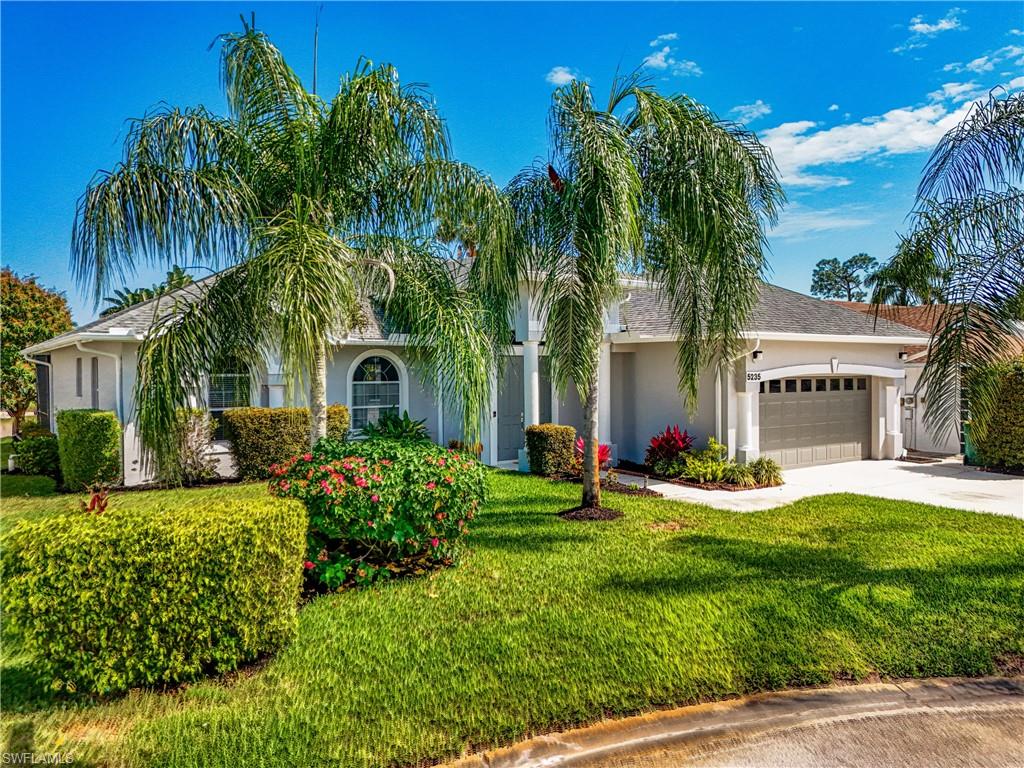 View of front of property with an attached garage, stucco siding, concrete driveway, and a front yard