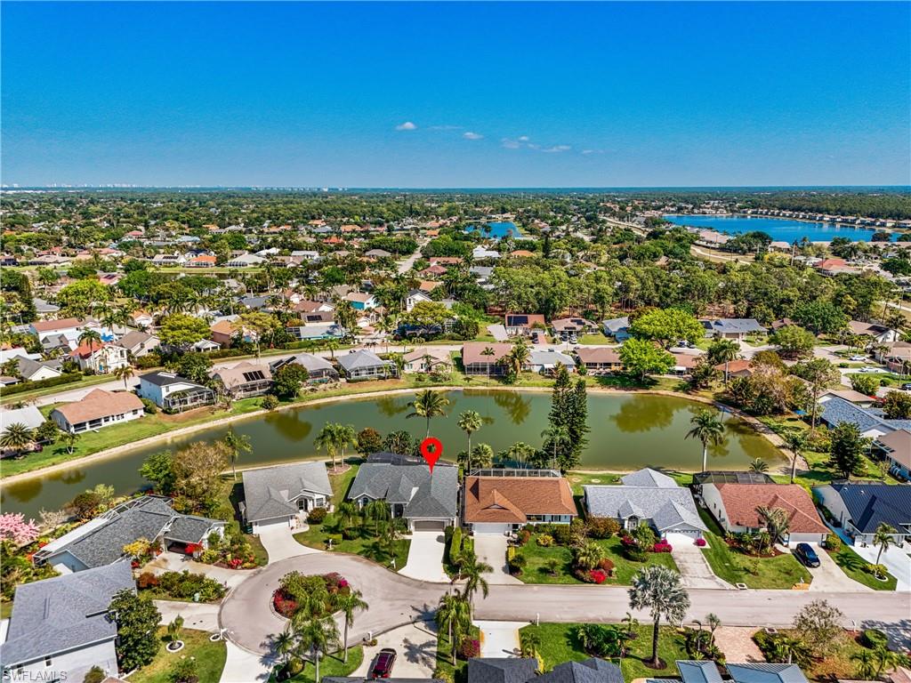 Aerial view of property and surrounding area featuring a large body of water and nearby suburban area