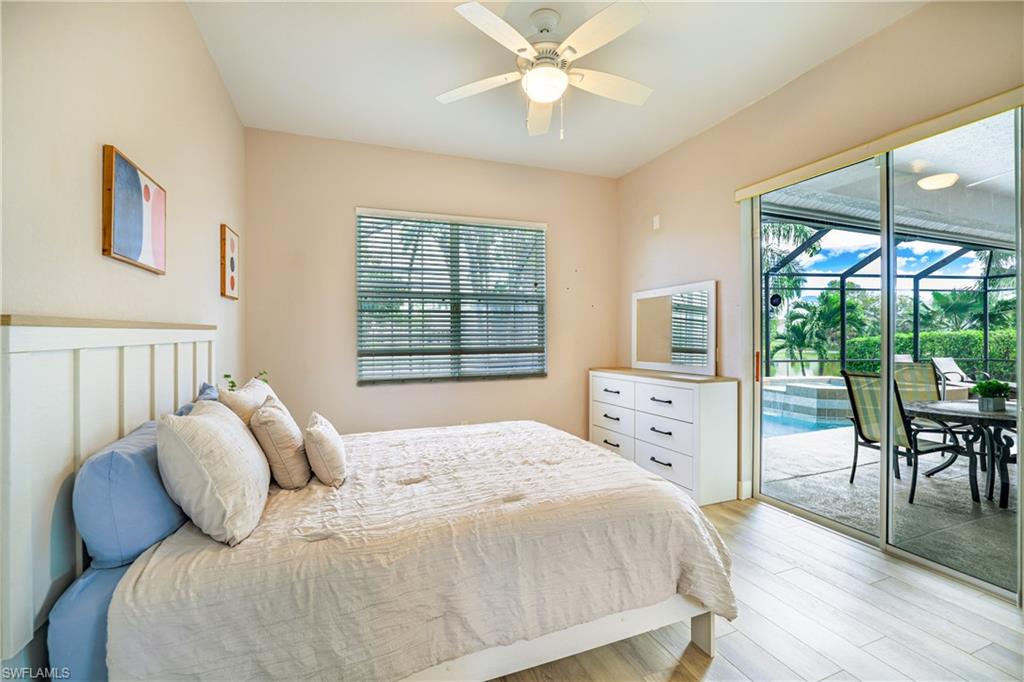 Bedroom with a sunroom, access to outside, light wood-style flooring, and a ceiling fan