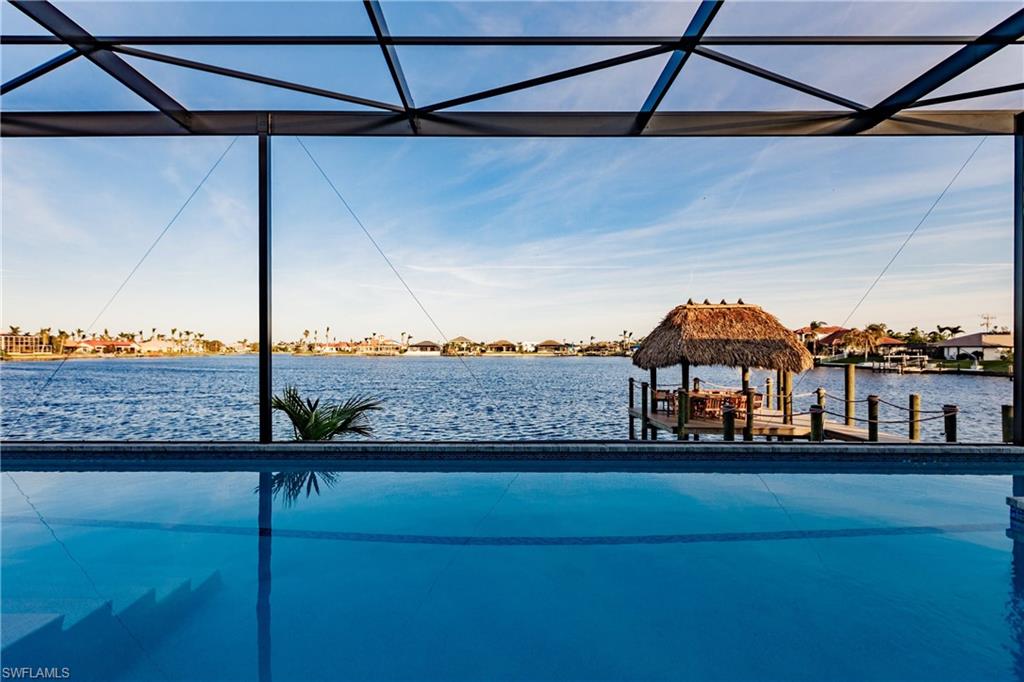 Outdoor pool featuring a water view and a dock