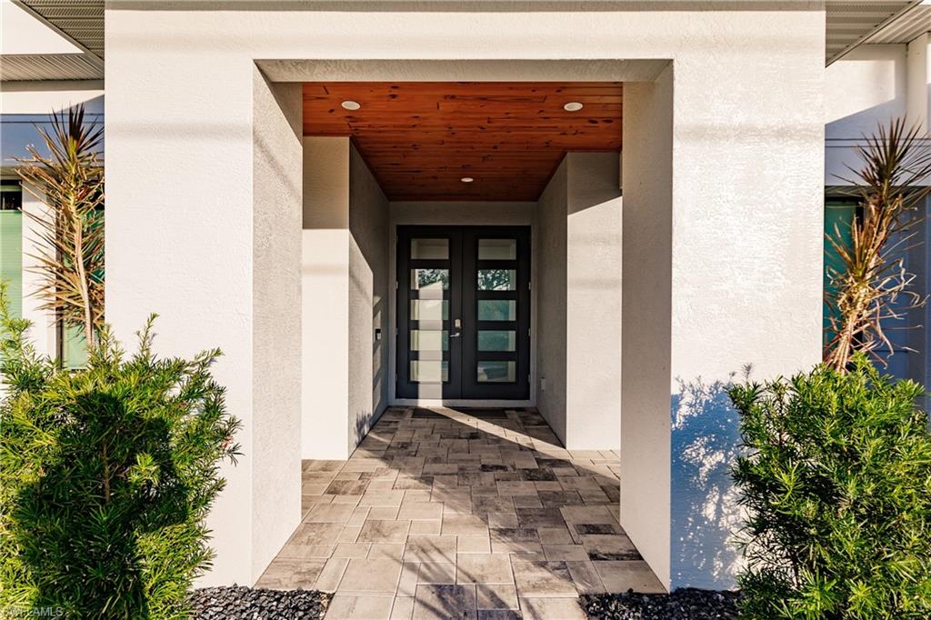 Doorway to property featuring french doors and stucco siding