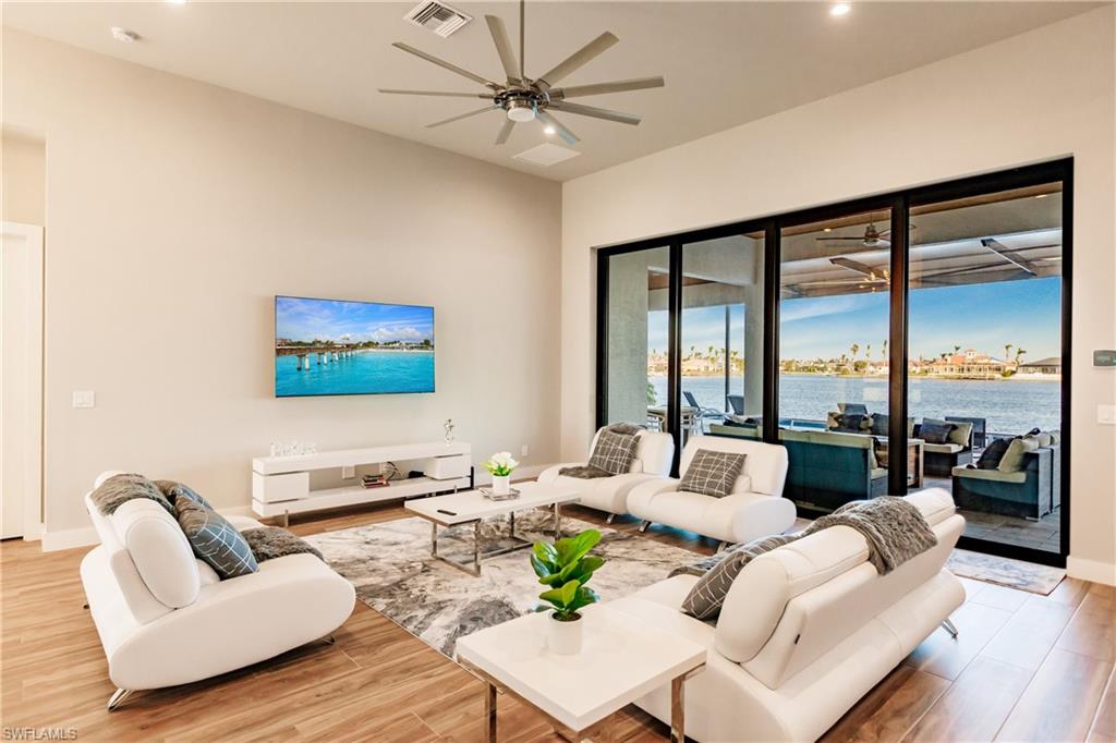 Living room featuring ceiling fan, wood finished floors, and recessed lighting