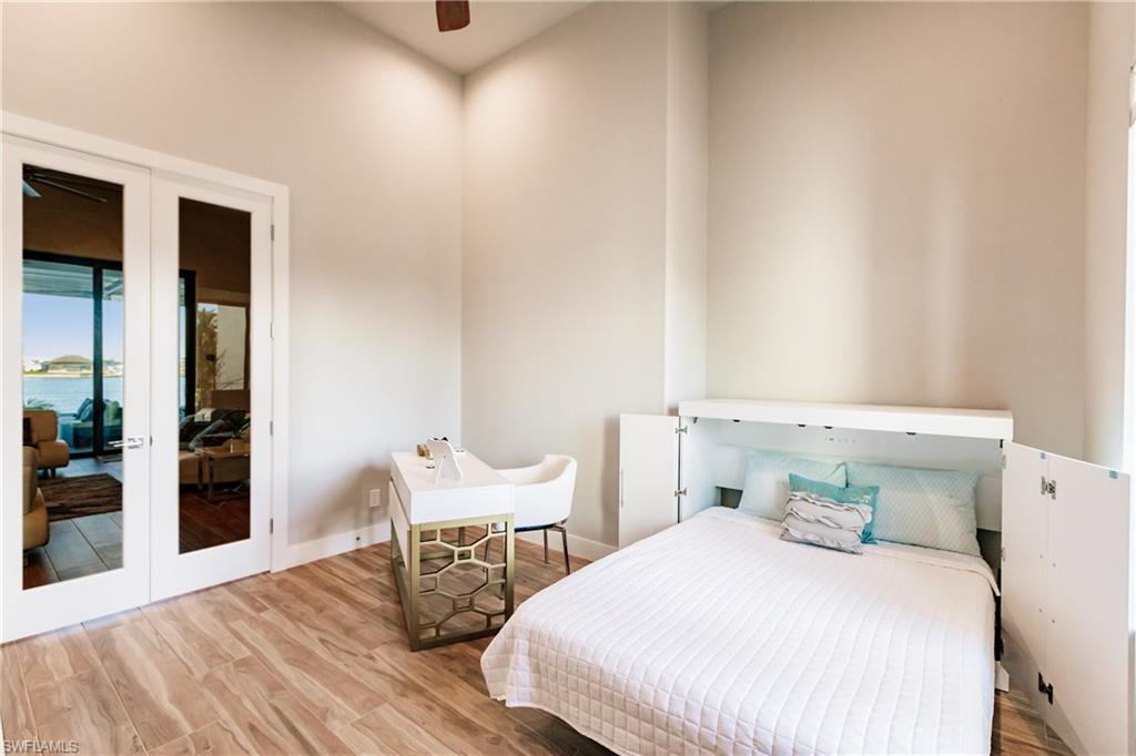 Bedroom with access to exterior, wood finished floors, and ceiling fan