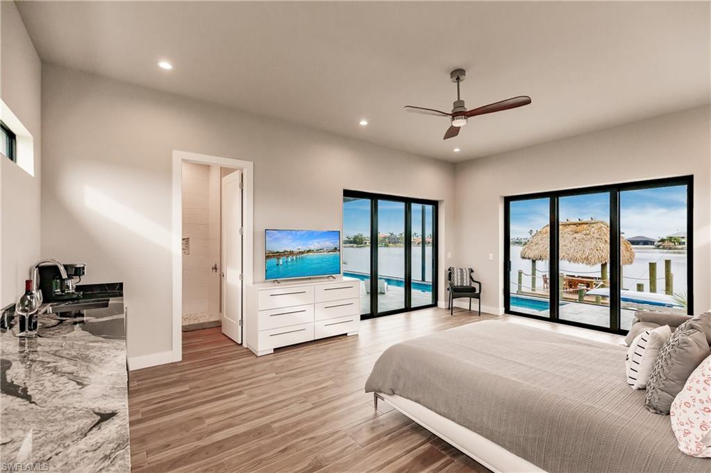 Bedroom featuring access to outside, multiple windows, light wood-type flooring, recessed lighting, and a ceiling fan
