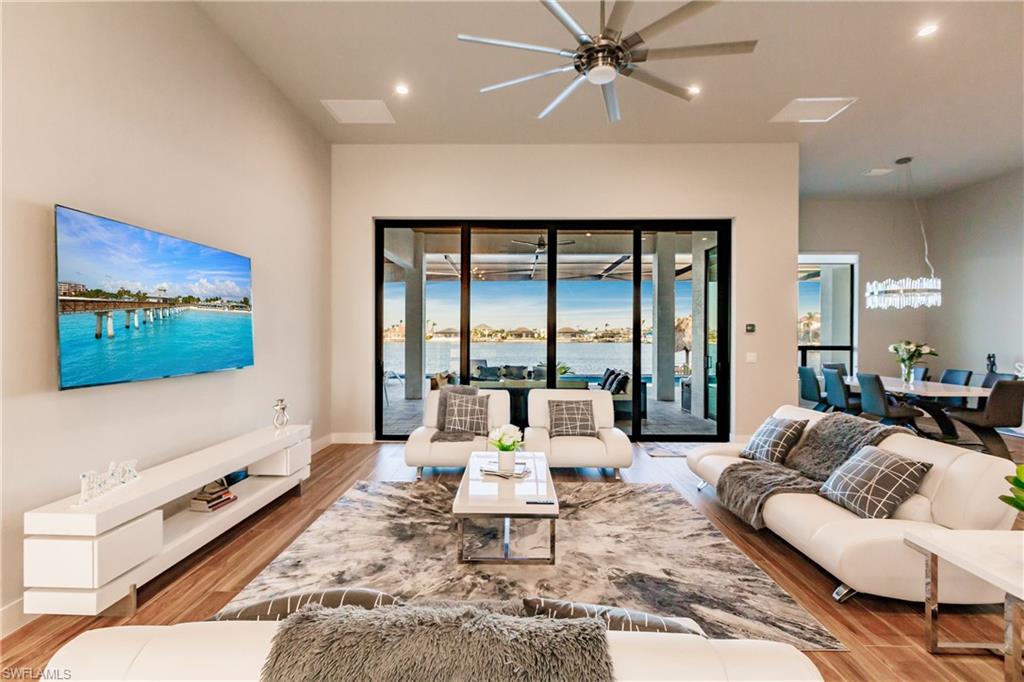 Living room featuring ceiling fan, wood finished floors, recessed lighting, and a chandelier