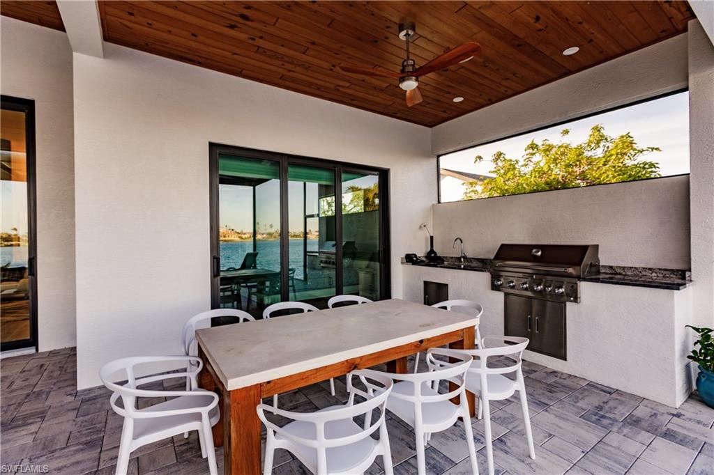 View of patio / terrace featuring exterior kitchen, a ceiling fan, and outdoor dining area