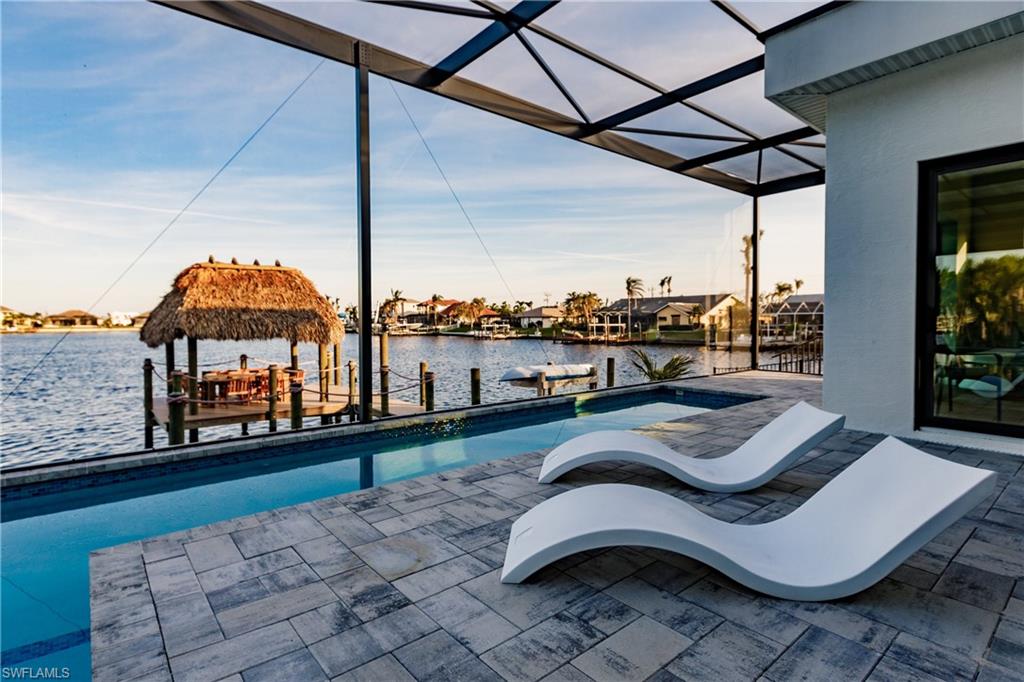 Swimming pool featuring a water view, a patio area, a gazebo, and a lanai