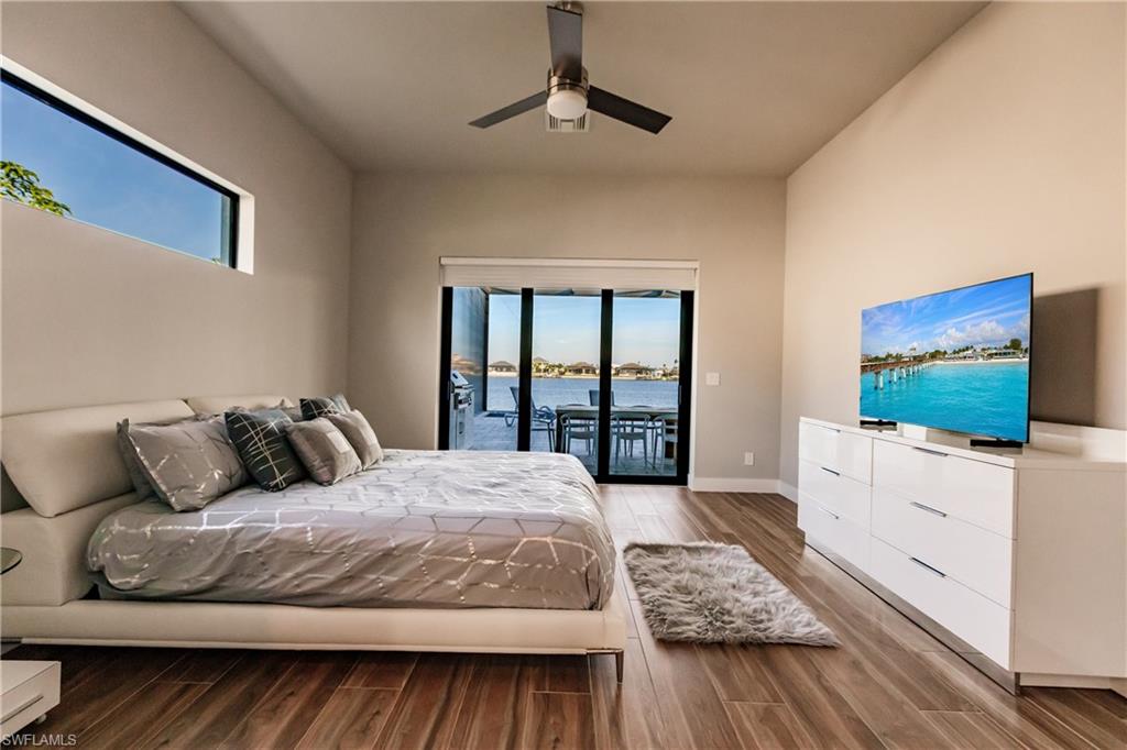 Bedroom with access to outside, wood finished floors, and a ceiling fan