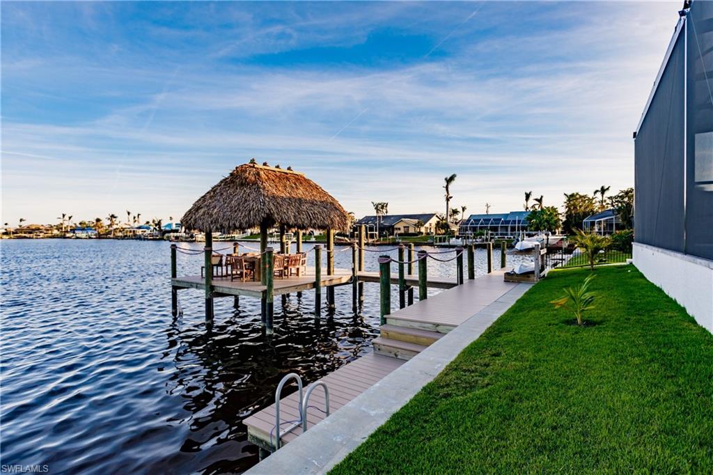 Dock area with a lawn, a water view, a gazebo, and boat lift