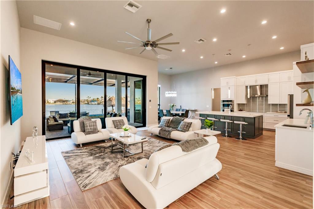 Living area with recessed lighting, ceiling fan, and light wood-style flooring