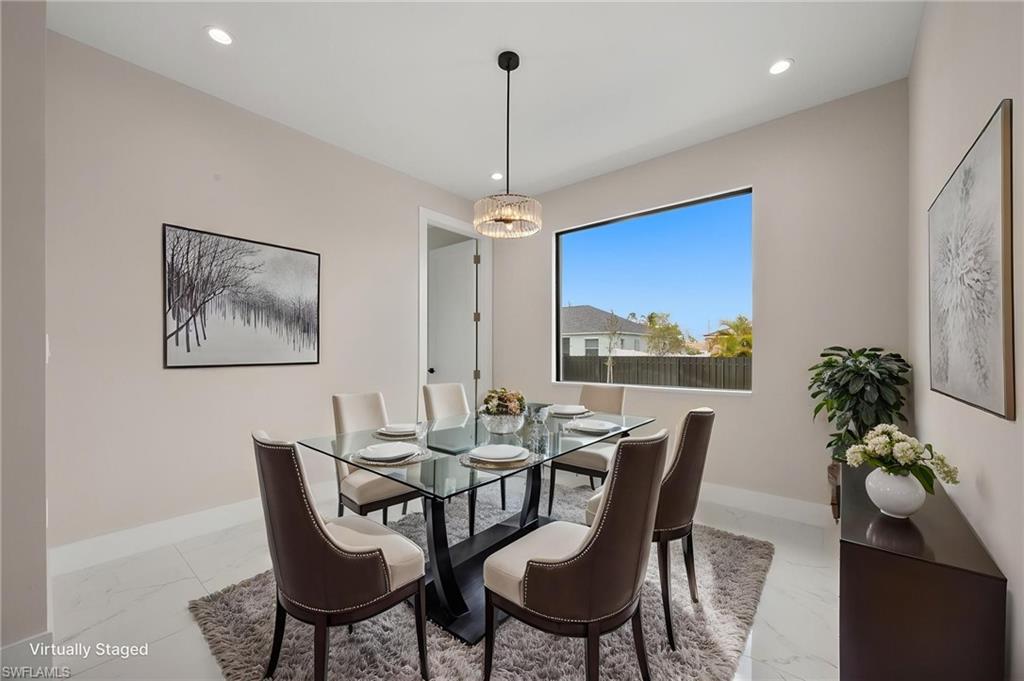 Dining area featuring recessed lighting and light marble finish floors