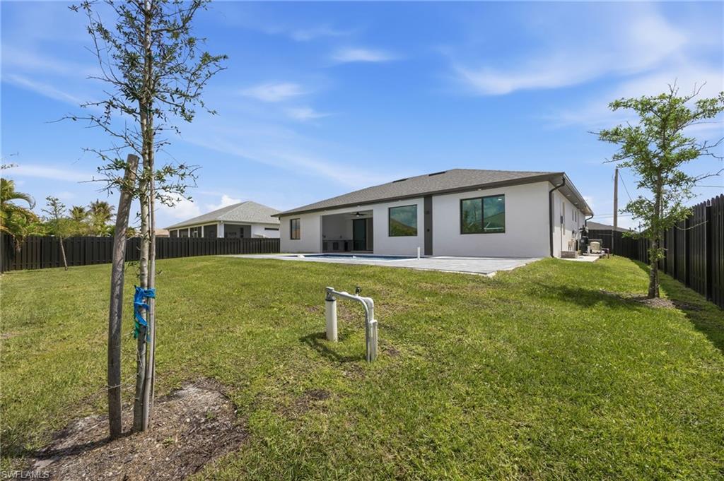 Back of property with a fenced backyard, a patio, and stucco siding