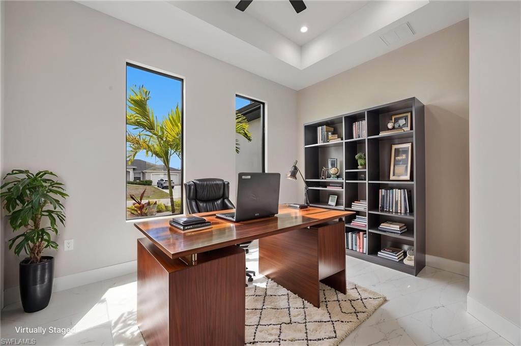Office with ceiling fan, light marble finish floors, a tray ceiling, and recessed lighting