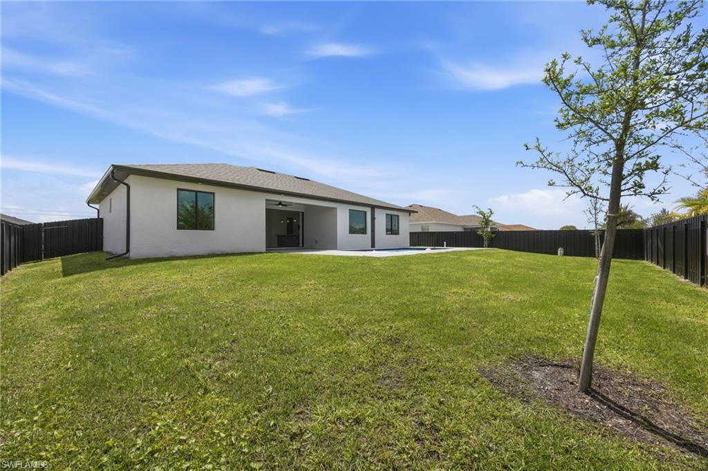 Rear view of property featuring a fenced backyard, a patio, and stucco siding
