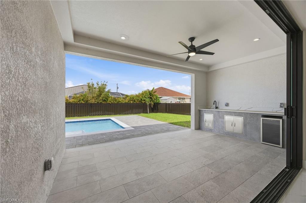 Fenced backyard with area for grilling, a patio, and a ceiling fan