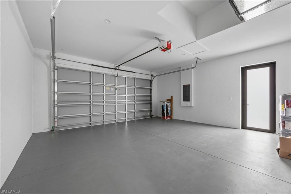Garage featuring electric panel and a garage door opener