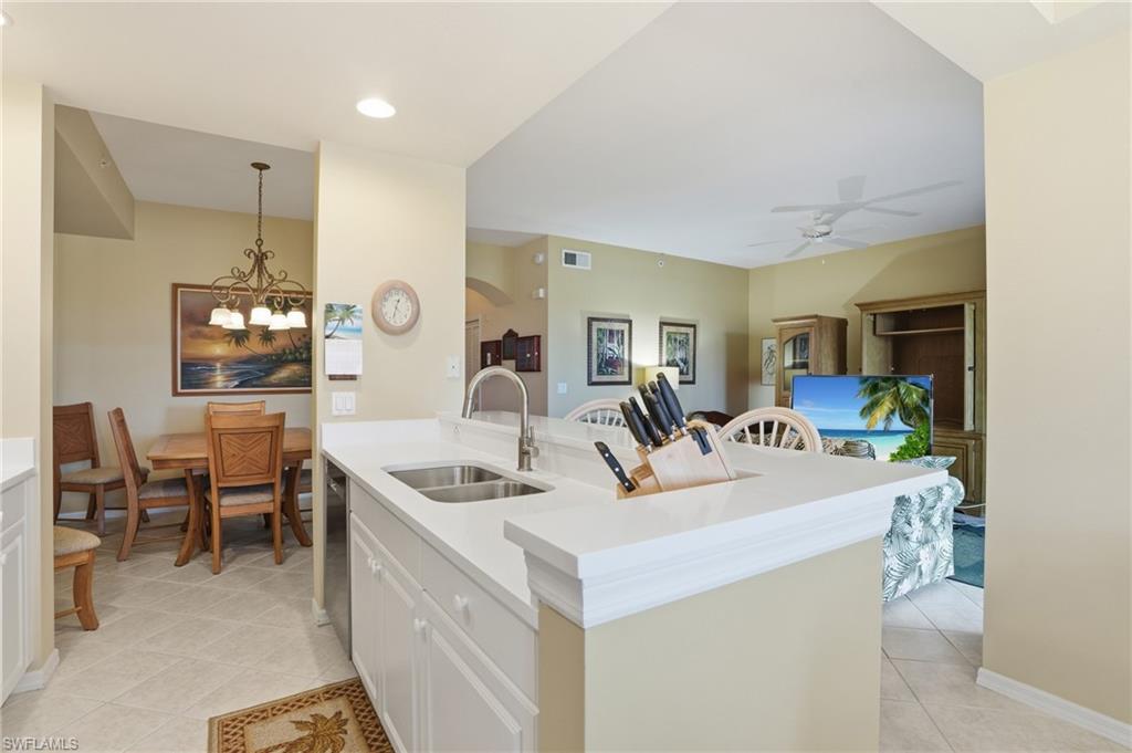 The kitchen features a double basin sink, light-colored countertops, and white cabinetry