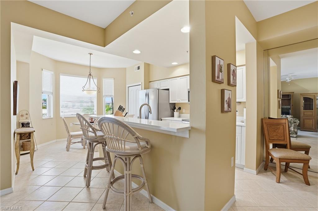 The property features a kitchen with white cabinetry, stainless steel appliances, and a breakfast bar