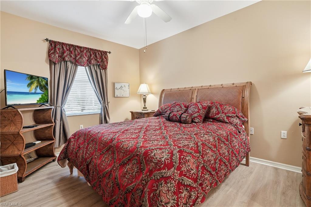 Bedroom featuring light-colored walls, wood-look flooring, and a ceiling fan