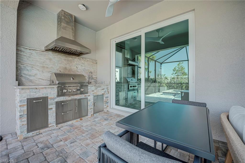 Fully equipped outdoor kitchen featuring a built in grill, prep sink, and ample storage