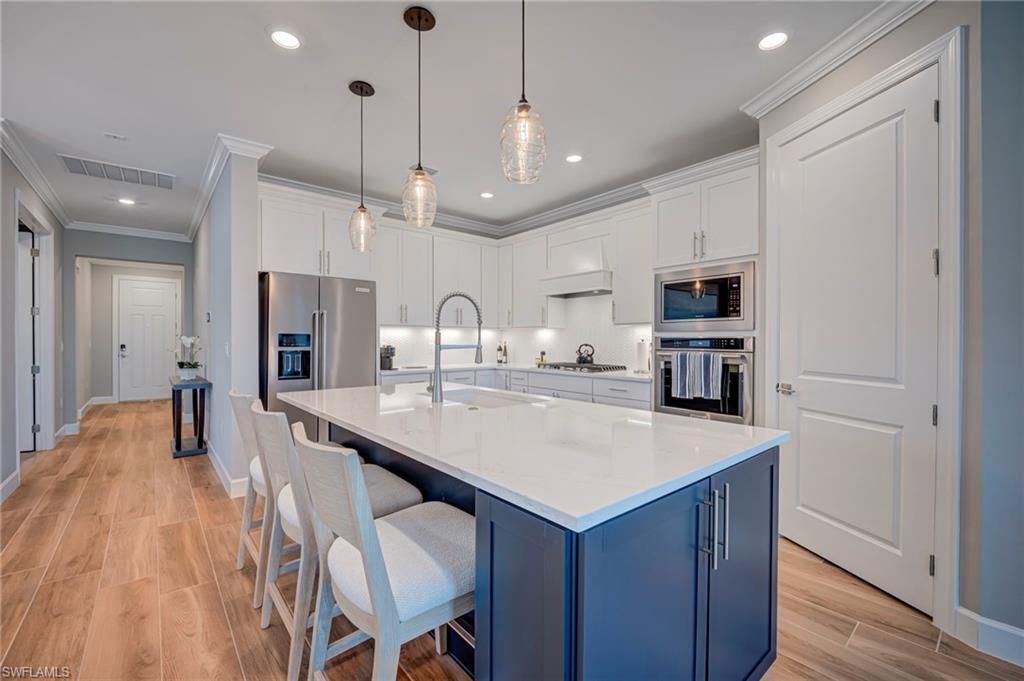 Open concept kitchen with quartz countertops white shaker cabinets, stainless steel appliances, great for entertaining!