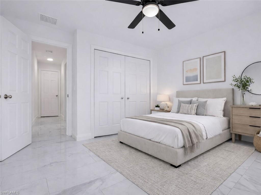 Bedroom with a ceiling fan, a closet, and light marble finish floors