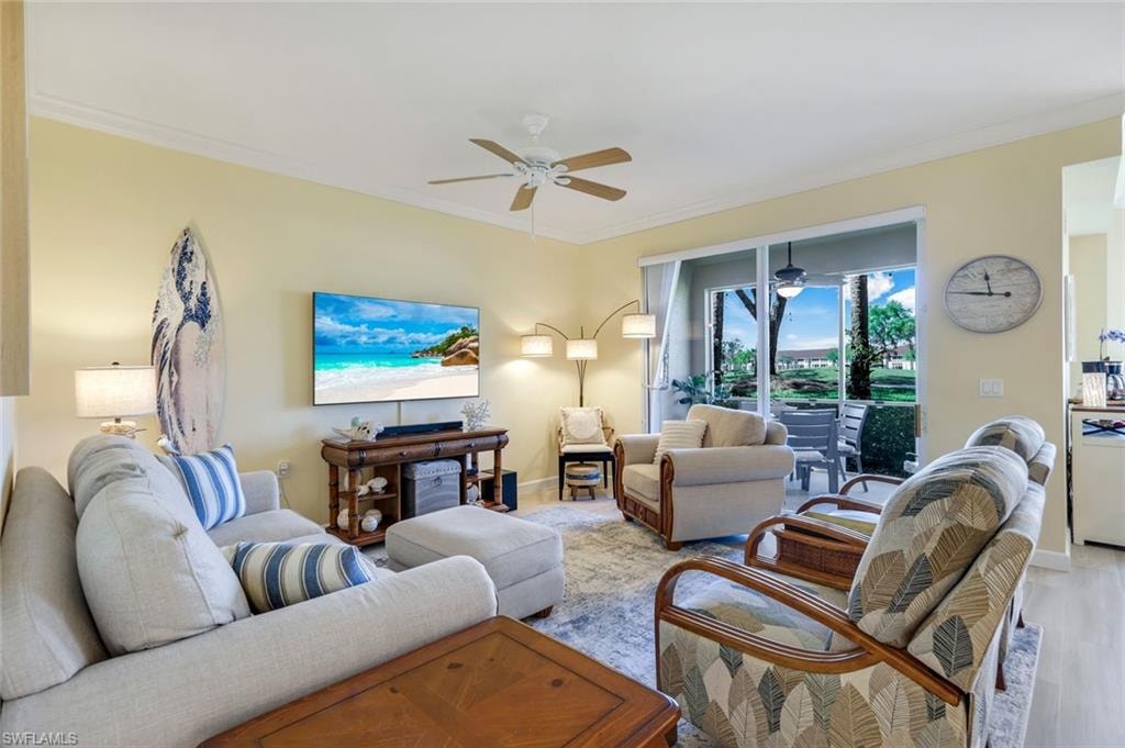 Living area with ceiling fan, light wood-style flooring, and ornamental molding