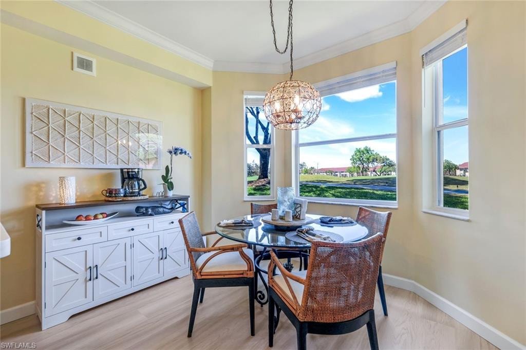 Dining space featuring visible vents, a chandelier, crown molding, light wood finished floors, and baseboards