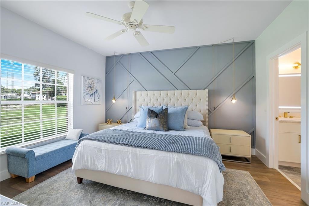 Bedroom with baseboards, ensuite bath, ceiling fan, and wood finished floors