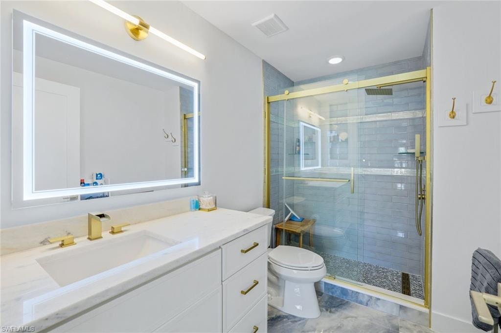 Full bath with a stall shower, toilet, and vanity