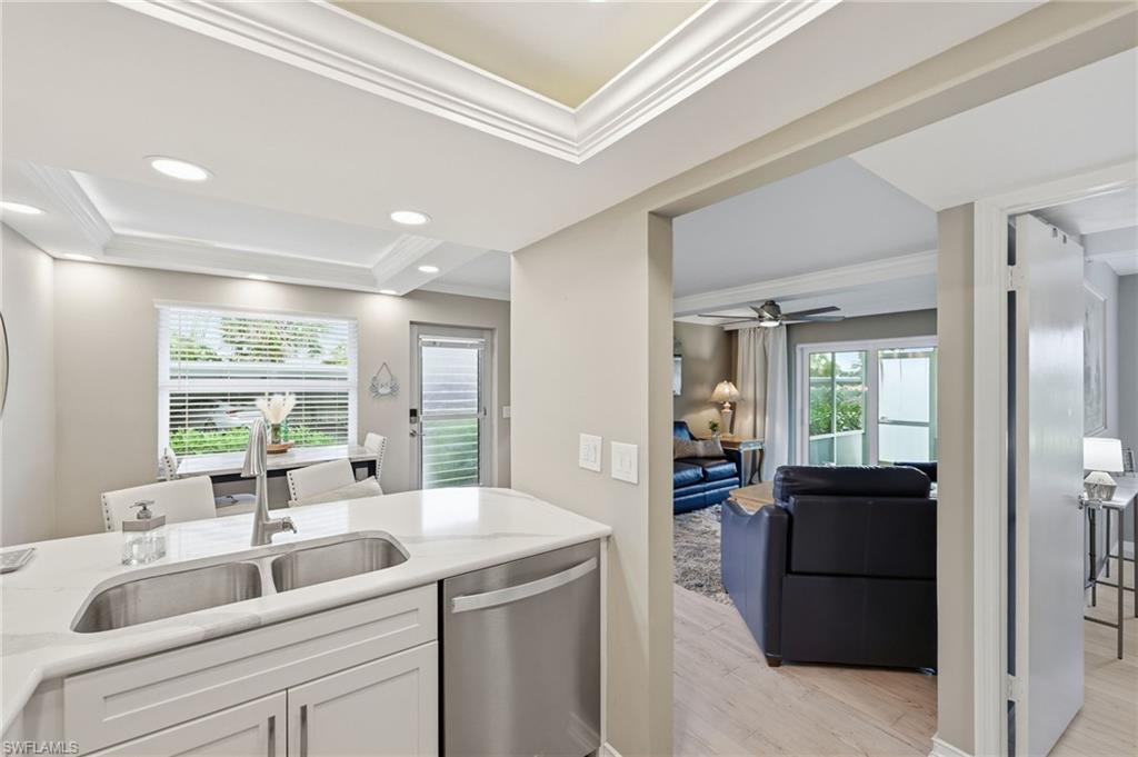 Kitchen peninsula with a double-basin stainless steel sink, gooseneck faucet, and quartz-finish countertop