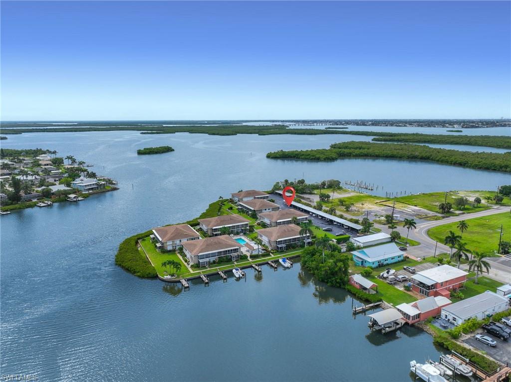 Waterfront property featuring multiple buildings, boat slips, and a swimming pool