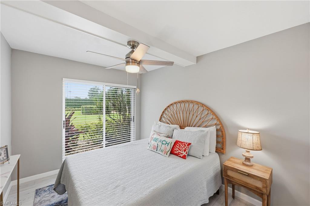 Sliding glass doors with horizontal blinds, light-toned walls, and a ceiling fan with integrated lighting