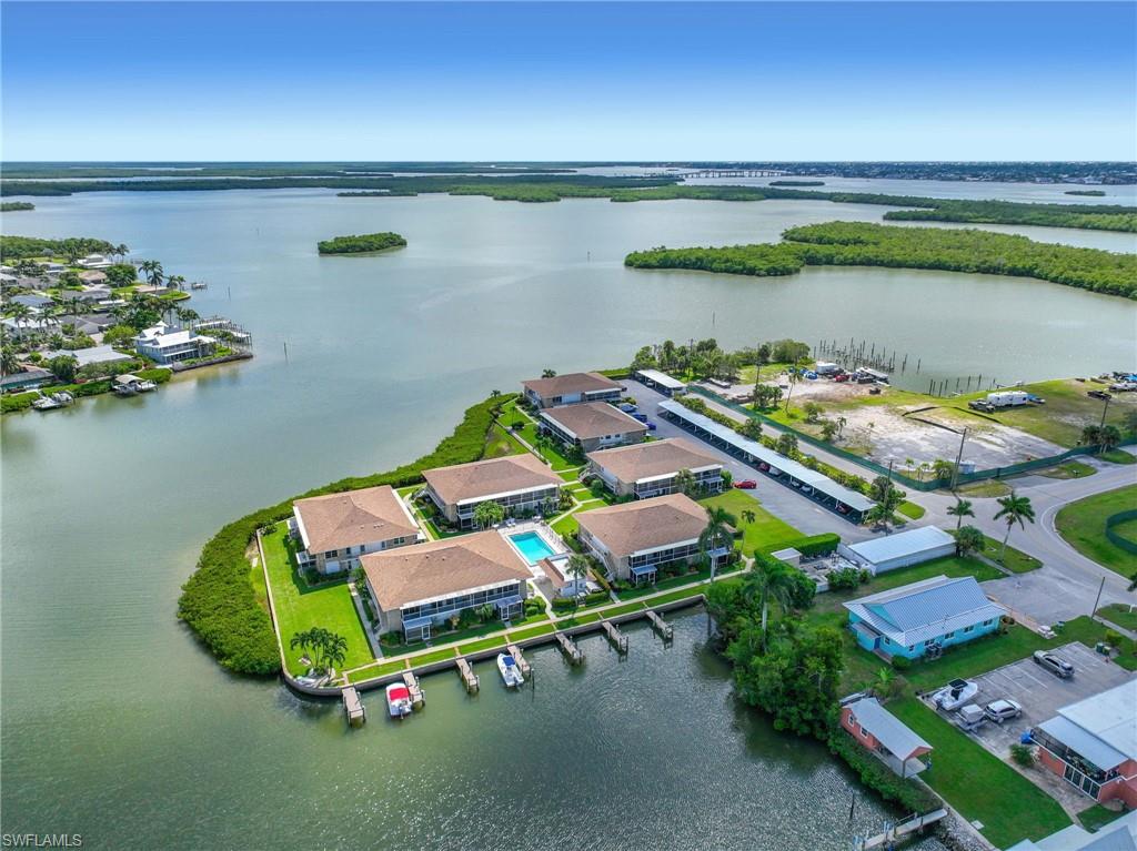 Waterfront property featuring multiple buildings, a swimming pool, private boat docks, and covered parking structures