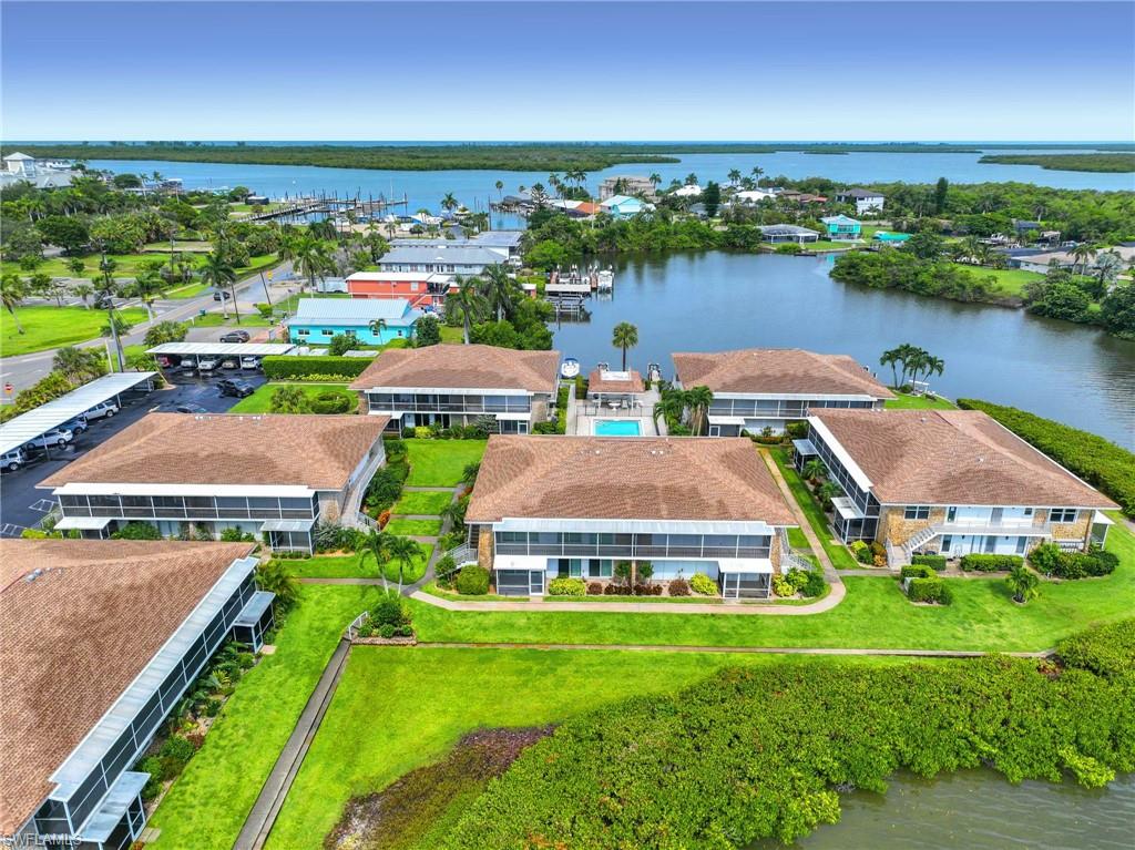 Waterfront property featuring multiple multi-story residential buildings with brown shingle roofs