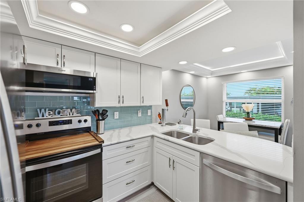 Bright kitchen with white cabinetry and stainless steel appliances
