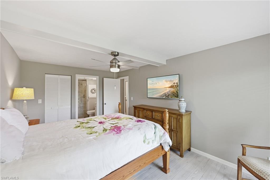 Bedroom featuring light wood-finish flooring, a ceiling fan with integrated lighting, and neutral wall tones