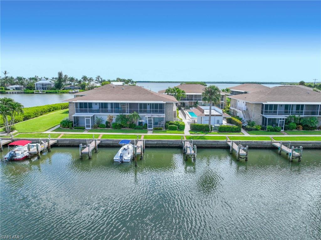 Waterfront property featuring multiple boat docks, screened balconies, and a communal swimming pool