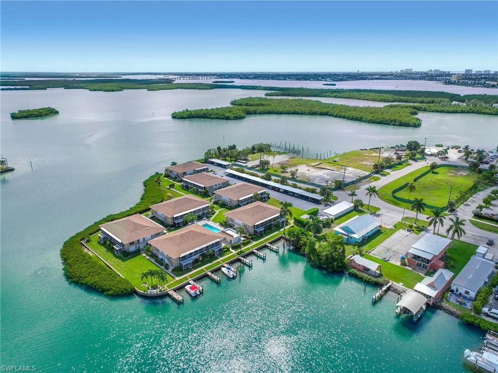 Waterfront property featuring multiple buildings with private boat docks, a swimming pool, and dedicated parking structures