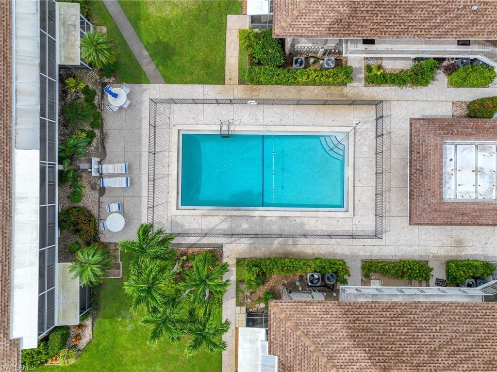 Rectangular swimming pool with a surrounding stone-finish deck, enclosed by fencing