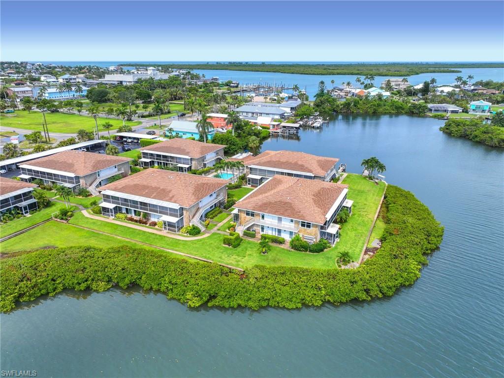 Waterfront community featuring multiple multi-story residences with screened porches and terracotta-style roofs