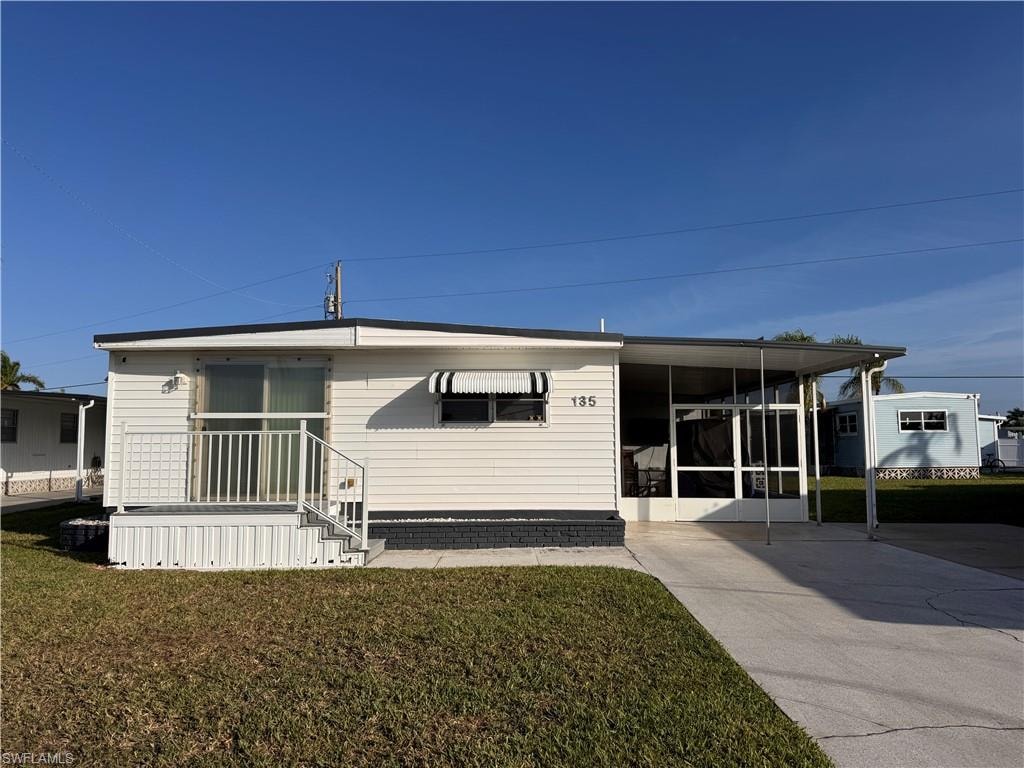 Front of home, slider featured with hurricane protection cover.  Ample Parking