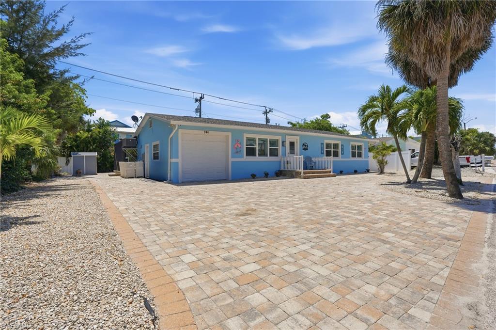 Single-story residence featuring a light blue exterior with white trim - Virtually Edited Image