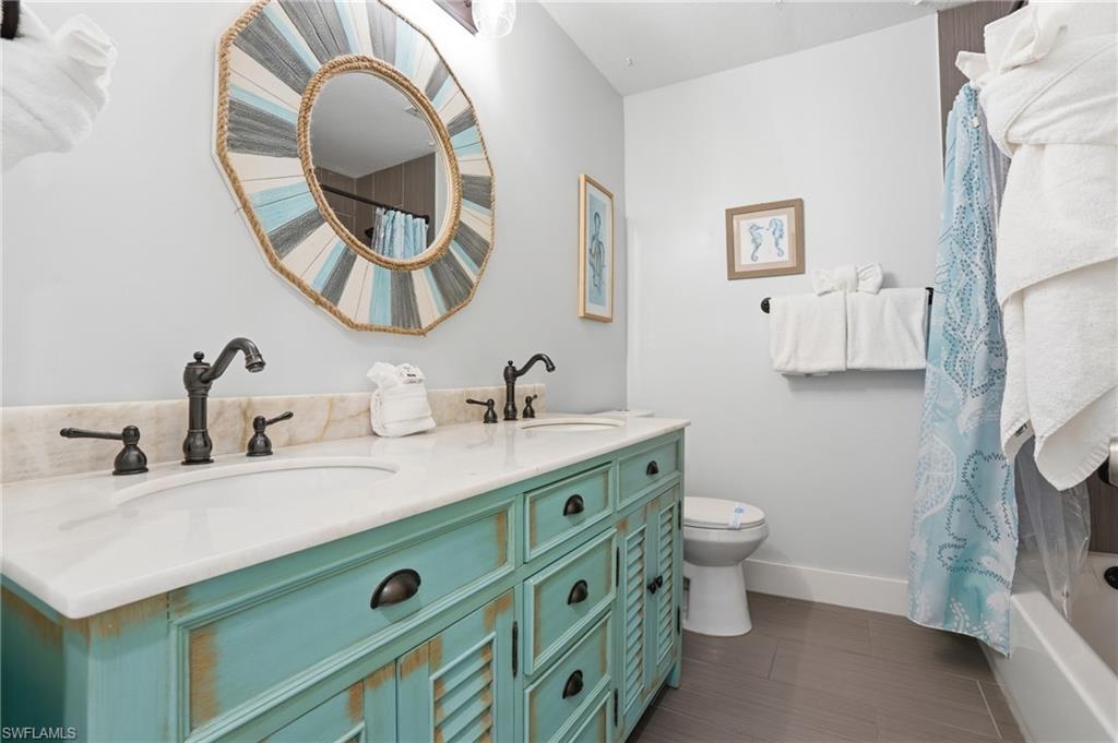 Double vanity with white countertop and distressed turquoise cabinetry - Virtually Edited Image